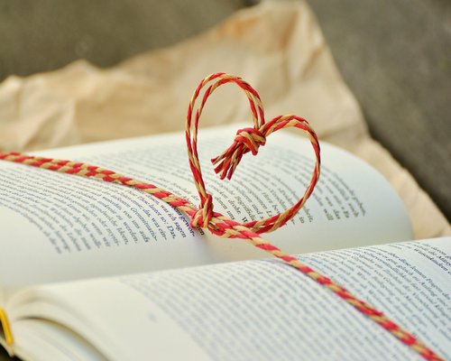 A person reading a book comfortably in a softly lit room